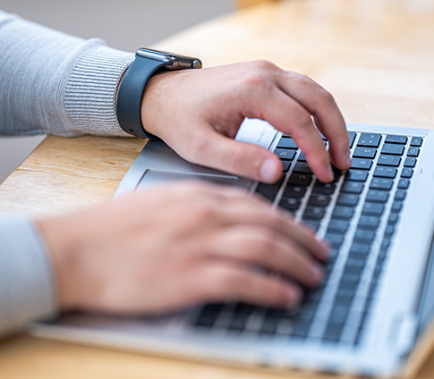 Two hands typing on a keyboard